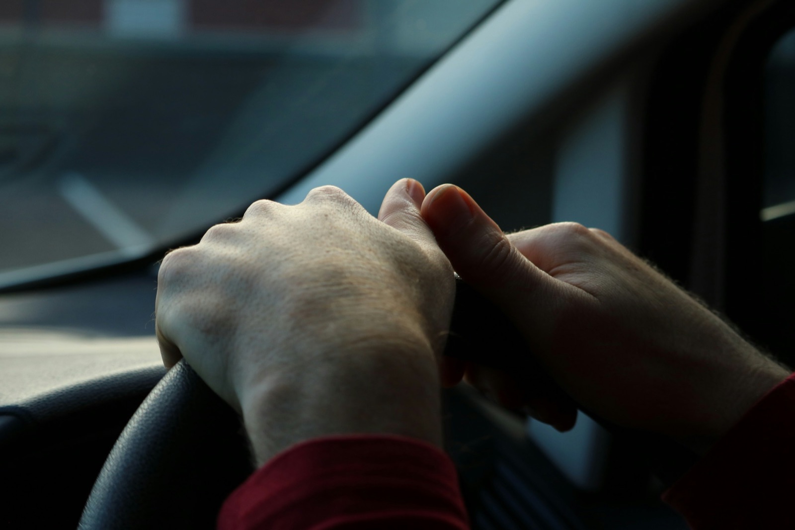 A driver’s hands resting on the steering wheel
